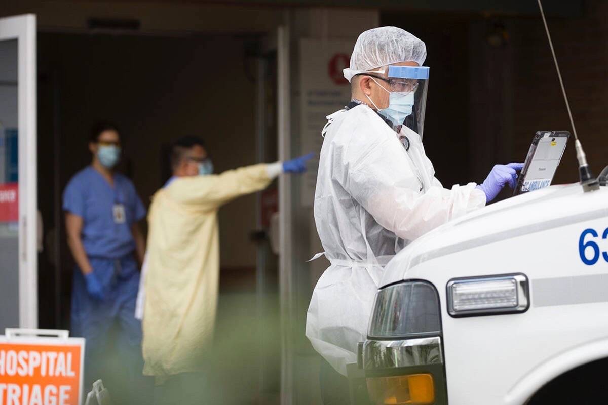 An ambulance paramedic in full protective gear works outside Lion’s Gate Hospital, March 23, 2020. Lion’s Gate Hospital and Lynn Valley Care Centre in North Vancouver were the first sites of major COVID-19 outbreaks in B.C. (The Canadian Press)