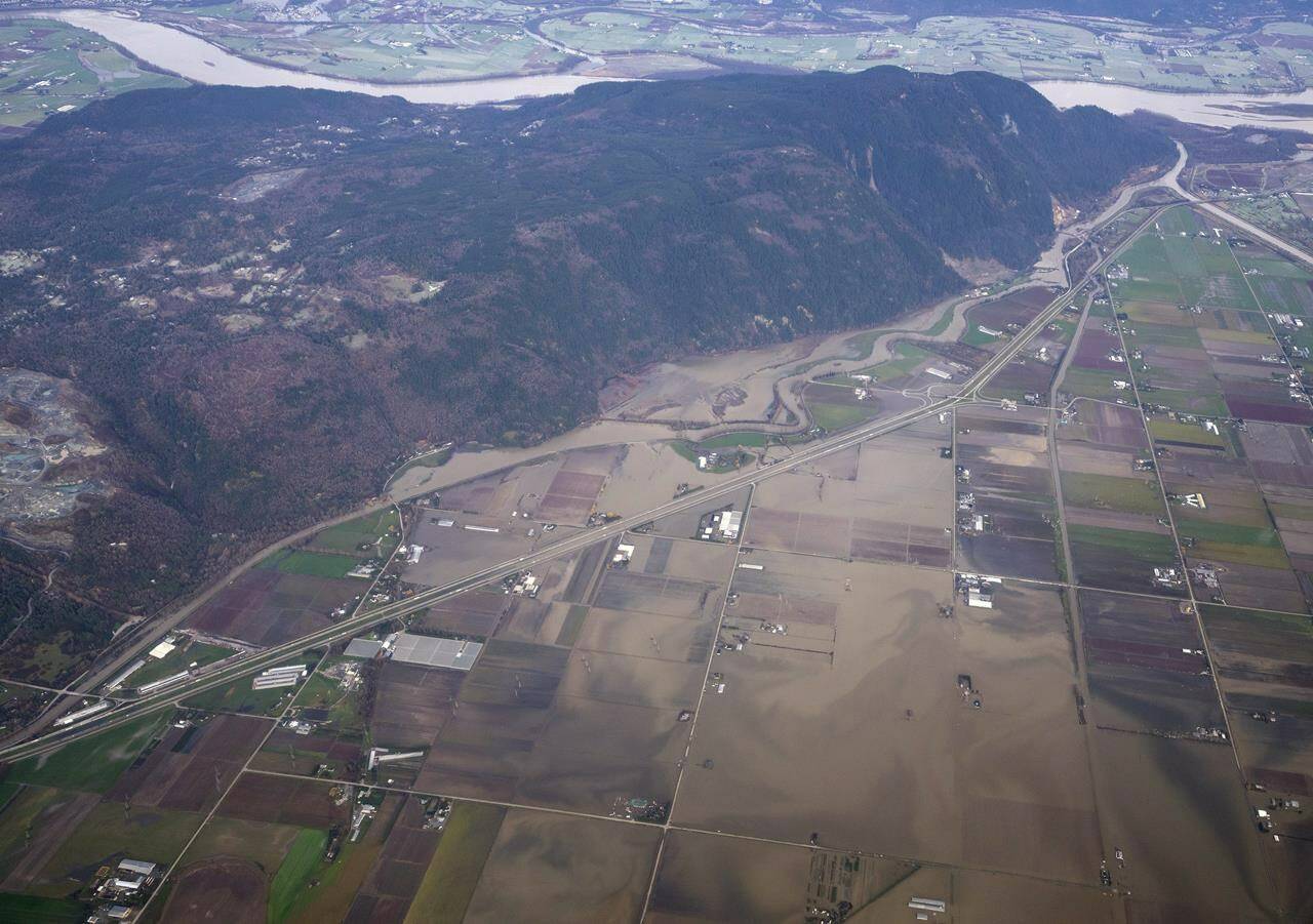 Flood waters are seen from a plane covering the fields and surrounding area of Abbotsford, B.C., Friday, Dec. 3, 2021. British Columbia’s finance minister says it’s still too early to put a price tag on the cleanup and repairs ahead following the recent devastating floods and slides in southern British Columbia. THE CANADIAN PRESS/Jonathan Hayward