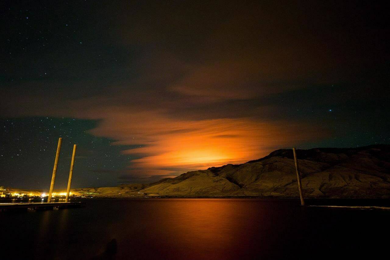 The Elephant Hill wildfire burns in the distance near Clinton, as seen from behind a mountain on Kamloops Lake in Savona, B.C., Sunday July 30, 2017. An Indigenous-led review of a massive wildfire that destroyed more than 100 homes in British Columbia’s southern Interior four years ago has produced 30 calls to action to improve wildfire management and recovery practices. THE CANADIAN PRESS/Darryl Dyck