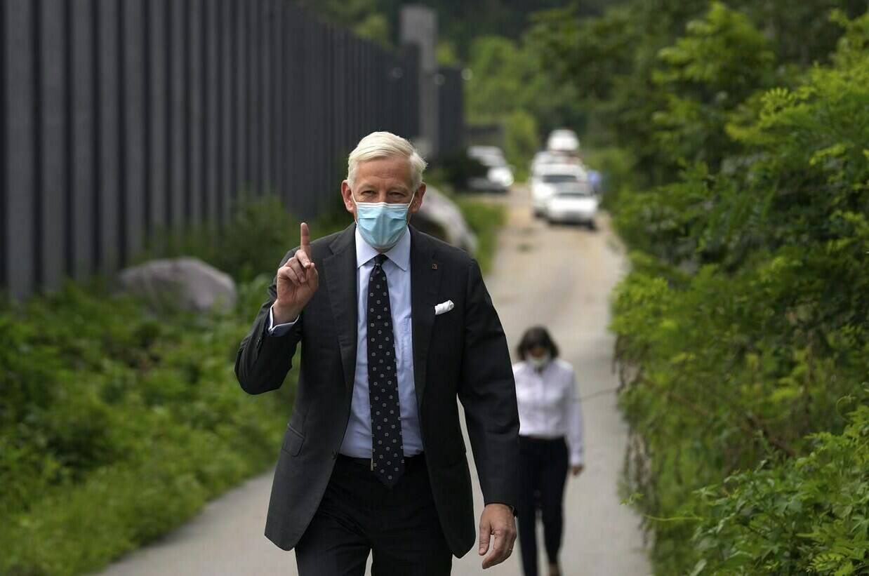 Dominic Barton, Canada Ambassador to China, wearing a face mask gestures after meeting with Canadian Michael Spavor at a detention center in Dandong, China, Wednesday, Aug. 11, 2021. Barton has tendered his resignation after two tense years in the job. THE CANADIAN PRESS/AP-Ng Han Guan