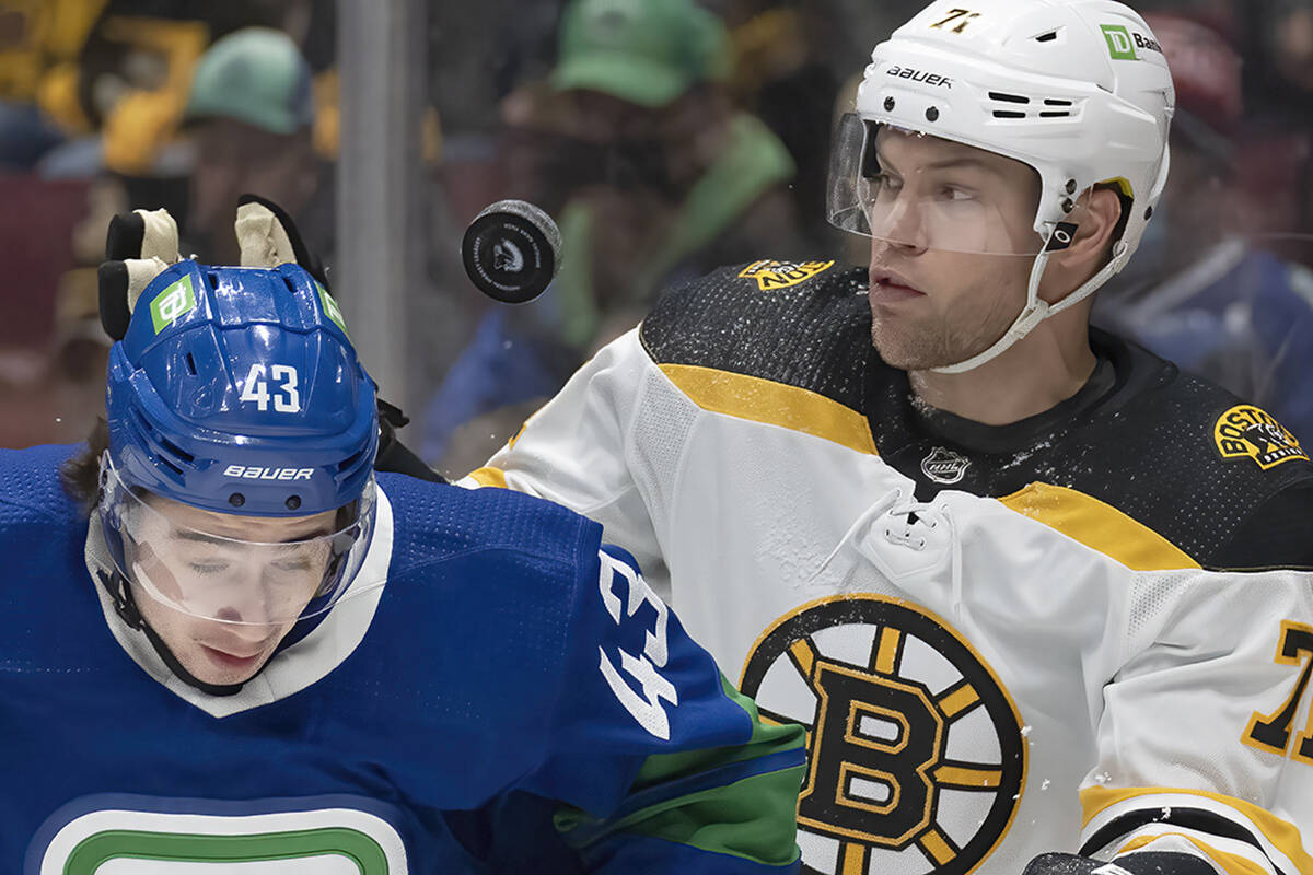 Boston Bruins left wing Taylor Hall (71) keeps his eye on the puck as he fights for control of the puck with Vancouver Canucks defenceman Quinn Hughes (43) during first period NHL action in Vancouver, Wednesday, December 8, 2021. THE CANADIAN PRESS/Jonathan Hayward