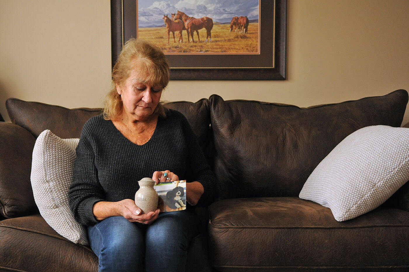 Shirley Sawatsky holds an urn and a photo of her dog Texas who was killed on Nov. 16 by two pit bulls. She is seen here in her Chilliwack home on Nov. 30, 2021. (Jenna Hauck/ Chilliwack Progress)