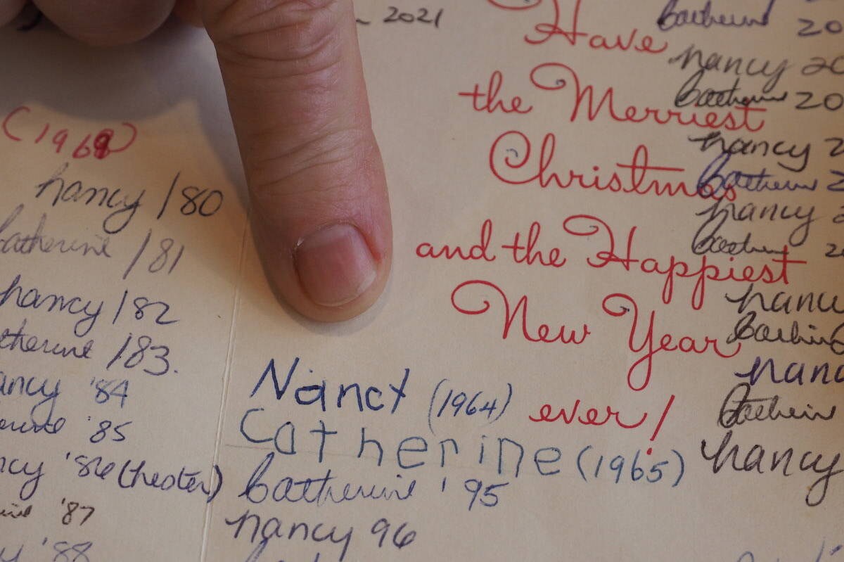 The first signatures of Catherine Crewe of Fernie, and Nancy Nester of Invermere in a Christmas card they have been sending back and forth to each other since 1964. Pictured: Catherine pointing to her and Nancy’s first signatures when they were both five years old. (Scott Tibballs / The Free Press)
