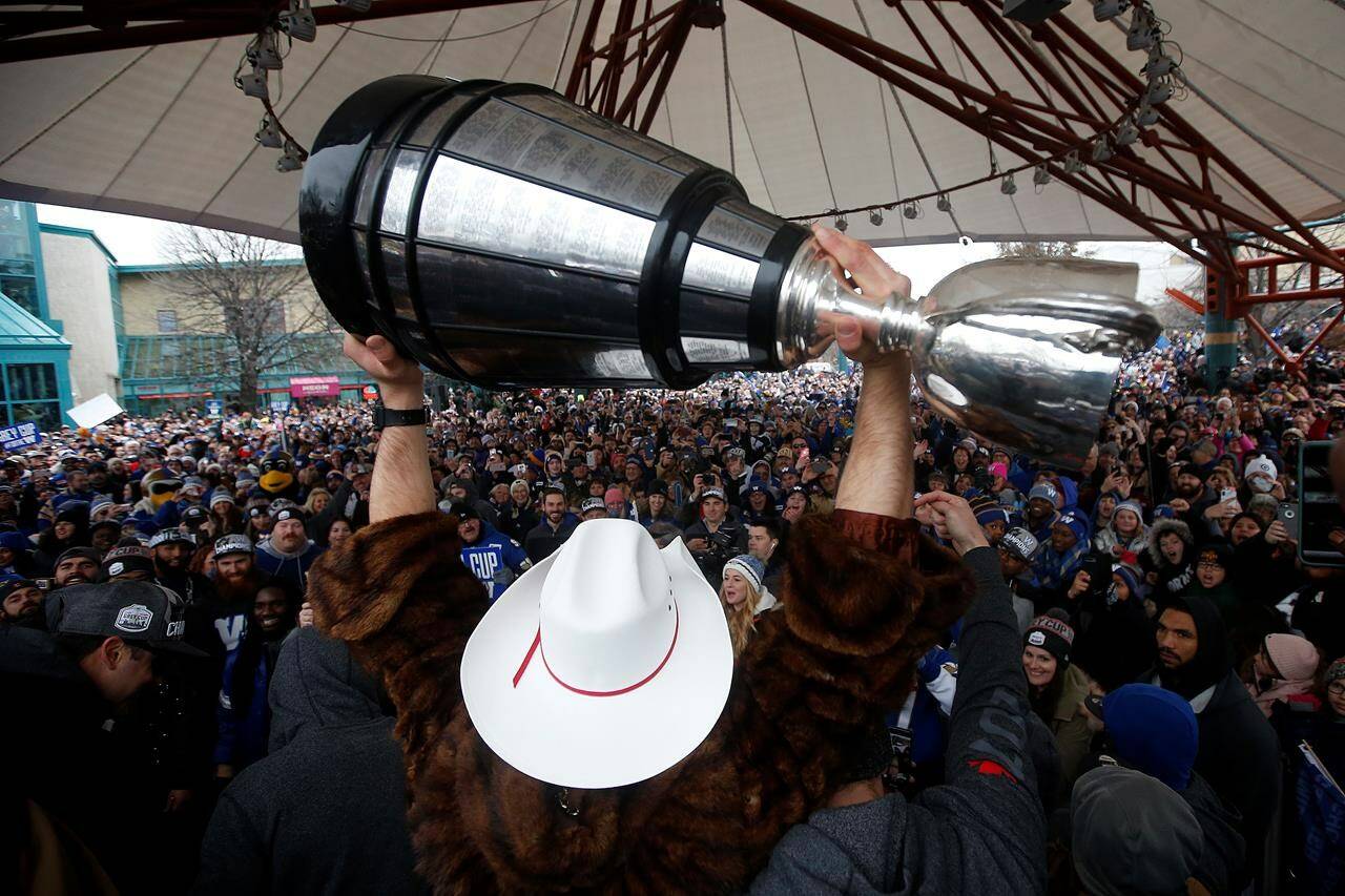 Winnipeggers crowd downtown streets in Winnipeg on Nov. 26, 2019, to celebrate with quarterback Chris Streveler as he raises the Grey Cup with other players after the Winnipeg Blue Bombers won their 11th Grey Cup with a 33-12 victory over the Hamilton Tiger-Cats in Calgary. THE CANADIAN PRESS/John Woods