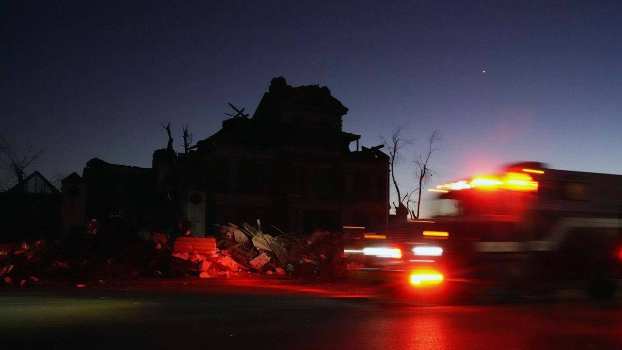 An emergency vehicle passes the damaged Graves County Courthouse Sunday, Dec. 12, 2021, in Mayfield, Ky. Tornadoes and severe weather caused catastrophic damage across several states Friday, killing multiple people. (AP Photo/Mark Humphrey)