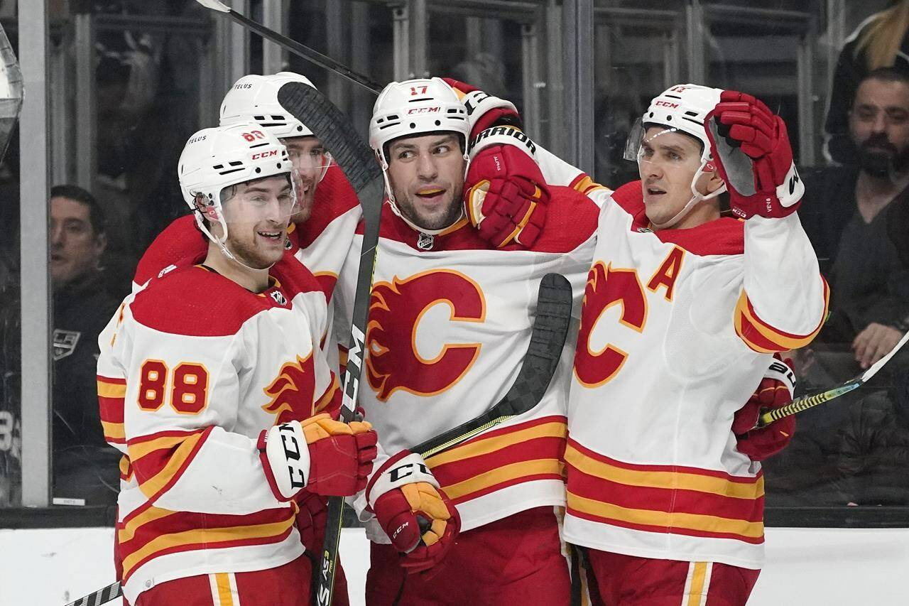 Calgary Flames left wing Milan Lucic, second from right, celebrates his goal with teammates left wing Andrew Mangiapane, left, defenceman Noah Hanifin, second from left, and centre Mikael Backlund during the first period of an NHL hockey game against the Los Angeles Kings Thursday, Dec. 2, 2021, in Los Angeles. Three more Calgary Flames have entered the NHL's COVID-19 protocol.THE CANADIAN PRESS/AP/Mark J. Terrill