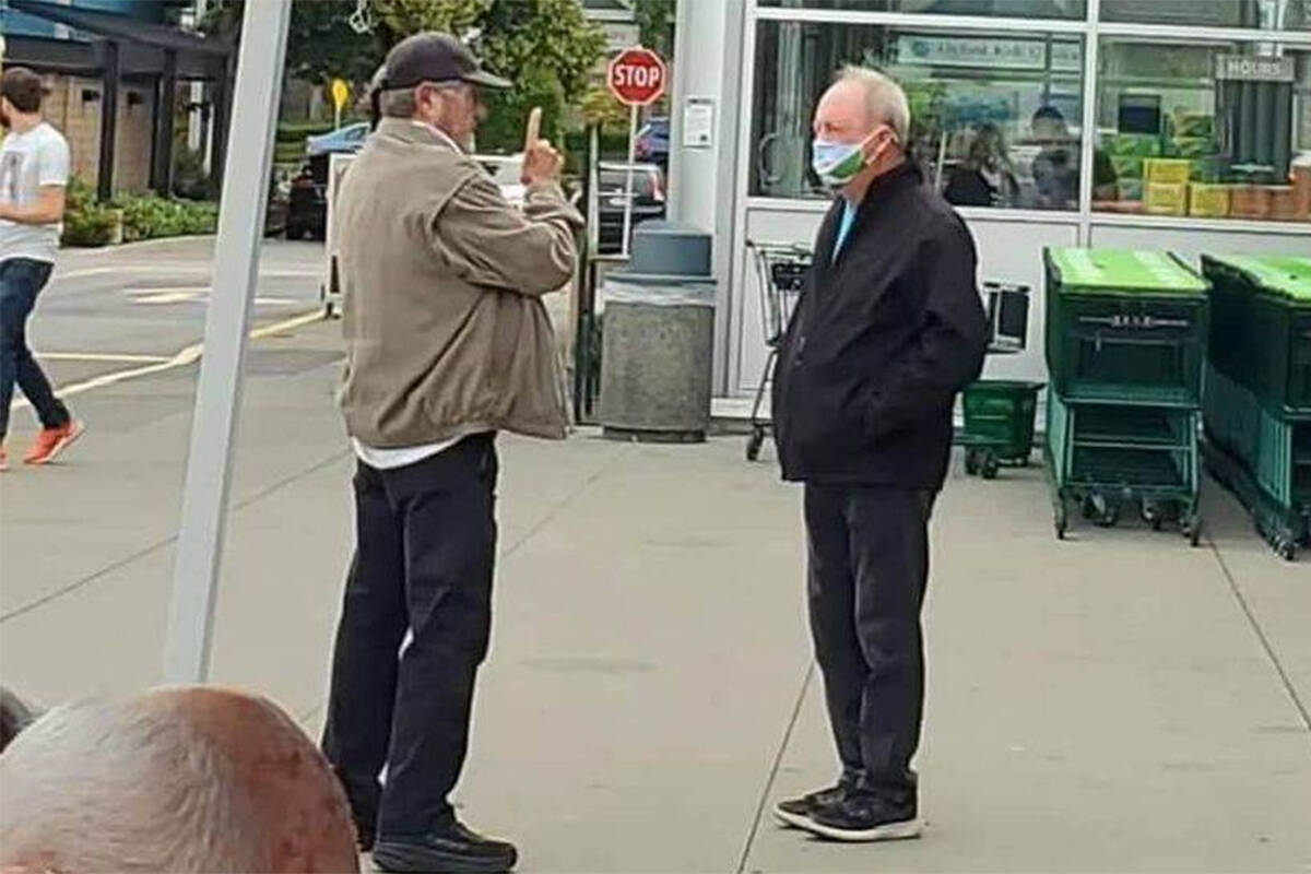 Keep the RCMP in Surrey campaign founder Ivan Scott (left) speaks to Surrey Mayor Doug McCallum in South Surrey Saturday, Sept. 4 after McCallum claimed one of Scott’s supporters ran over his foot with their car. (@captainramona Twitter photo)