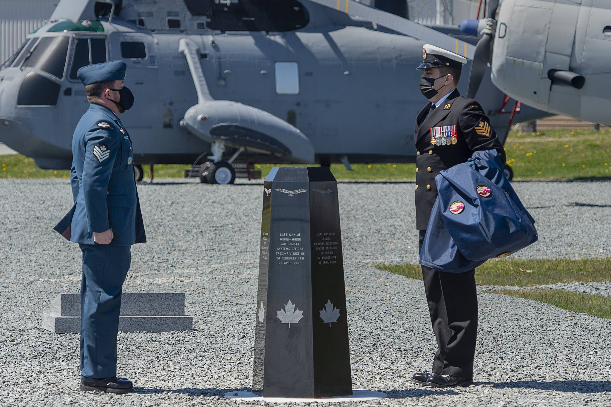 A sailor and an aviator observe a moment of silence after unveiling a memorial at 12 Wing Shearwater in Dartmouth, N.S. on the first anniversary of a CH-148 Cyclone helicopter crash that claimed the lives of six Canadian Forces members when the aircraft plunged into the ocean, on Thursday, April 29, 2021. THE CANADIAN PRESS/Andrew Vaughan