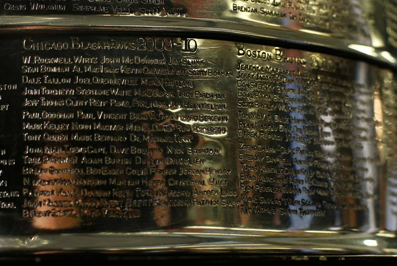 FILE - The names of the 2010 Stanley Cup Champion Chicago Blackhawks, left, are displayed on the Stanley Cup in the lobby of the United Center during an NHL hockey news conference on June 11, 2013 in Chicago. Representatives for the Blackhawks and a former player who is suing the team over how it handled his allegations of sexual assault against an assistant coach were meeting with a mediator Wednesday, Dec. 15, 2021 for the first time in hopes of resolving the case. (AP Photo/Charles Rex Arbogast, File)