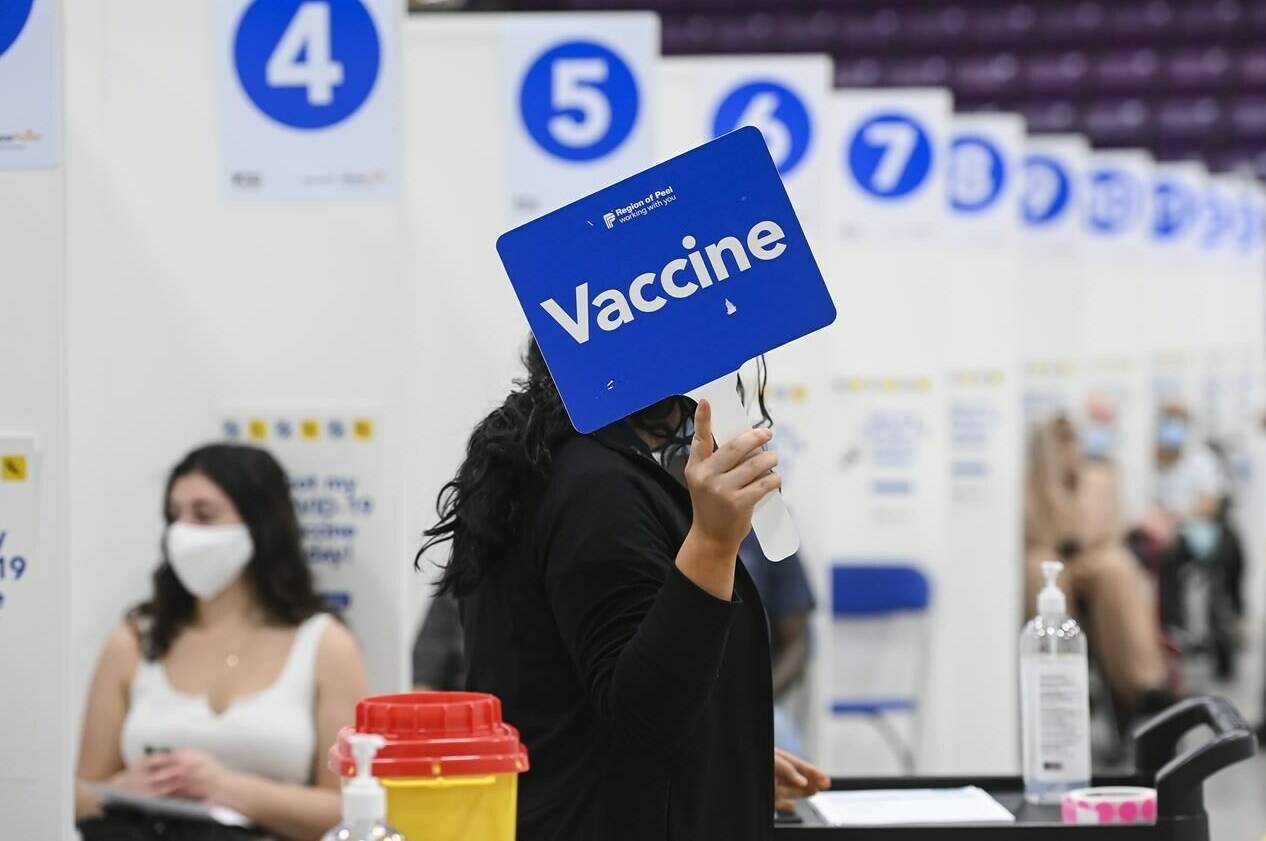 A health-care worker holds up a sign signalling she needs more COVID-19 vaccines at a mass vaccination facility at the CAA Centre during the COVID-19 pandemic in Brampton, Ont., on Friday, June 4, 2021. The push for Canadians to get their vaccine booster shots is ramping up as COVID-19’s Omicron variant spreads across the country triggering the return of pandemic restrictions in some provinces. THE CANADIAN PRESS/Nathan Denette