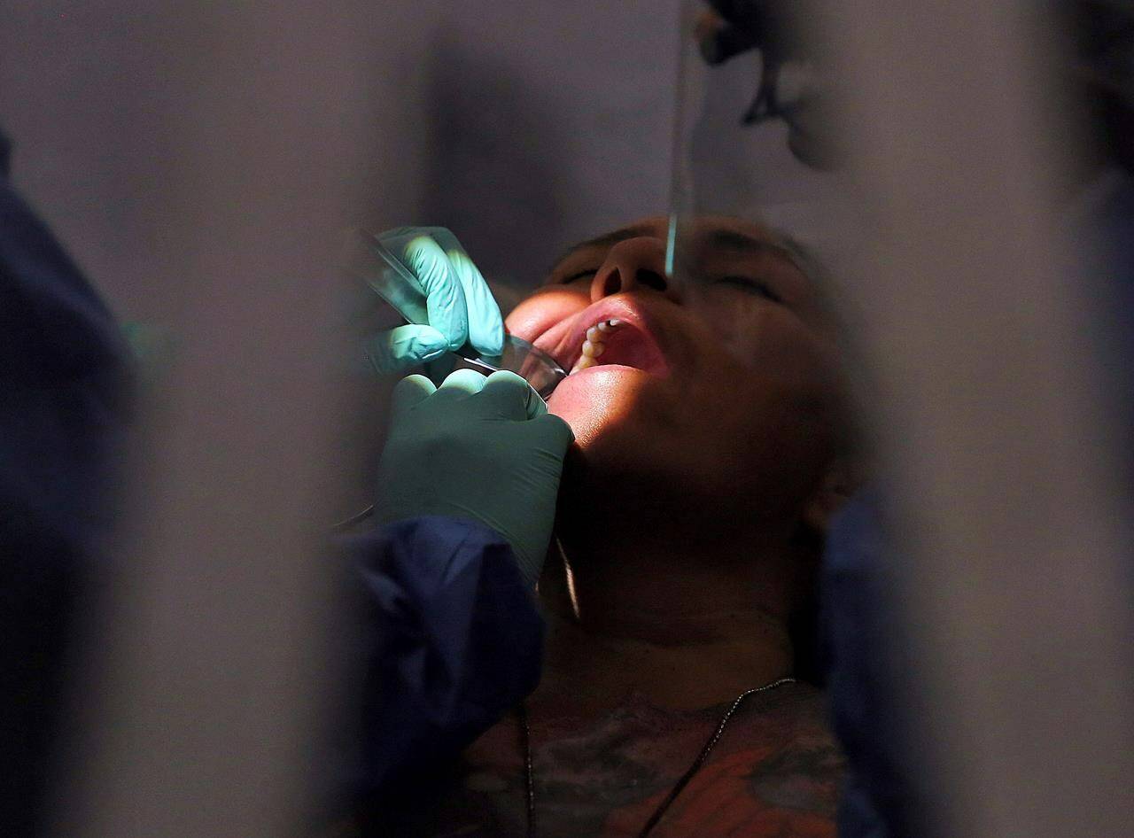 A dentist works on a patient on Monday, July 26, 2021, in San Juan, Texas. THE CANADIAN PRESS/AP-Joel Martinez/The Monitor via AP