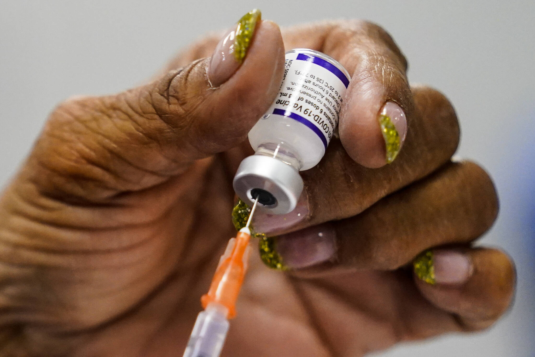 A syringe is prepared with the Pfizer COVID-19 vaccine at a vaccination clinic at the Keystone First Wellness Center in Chester, Pa., Wednesday, Dec. 15, 2021. As of Monday, Dec. 20, 87.3 per cent of eligible people five and older in B.C. have received their first vaccine dose. (AP Photo/Matt Rourke)