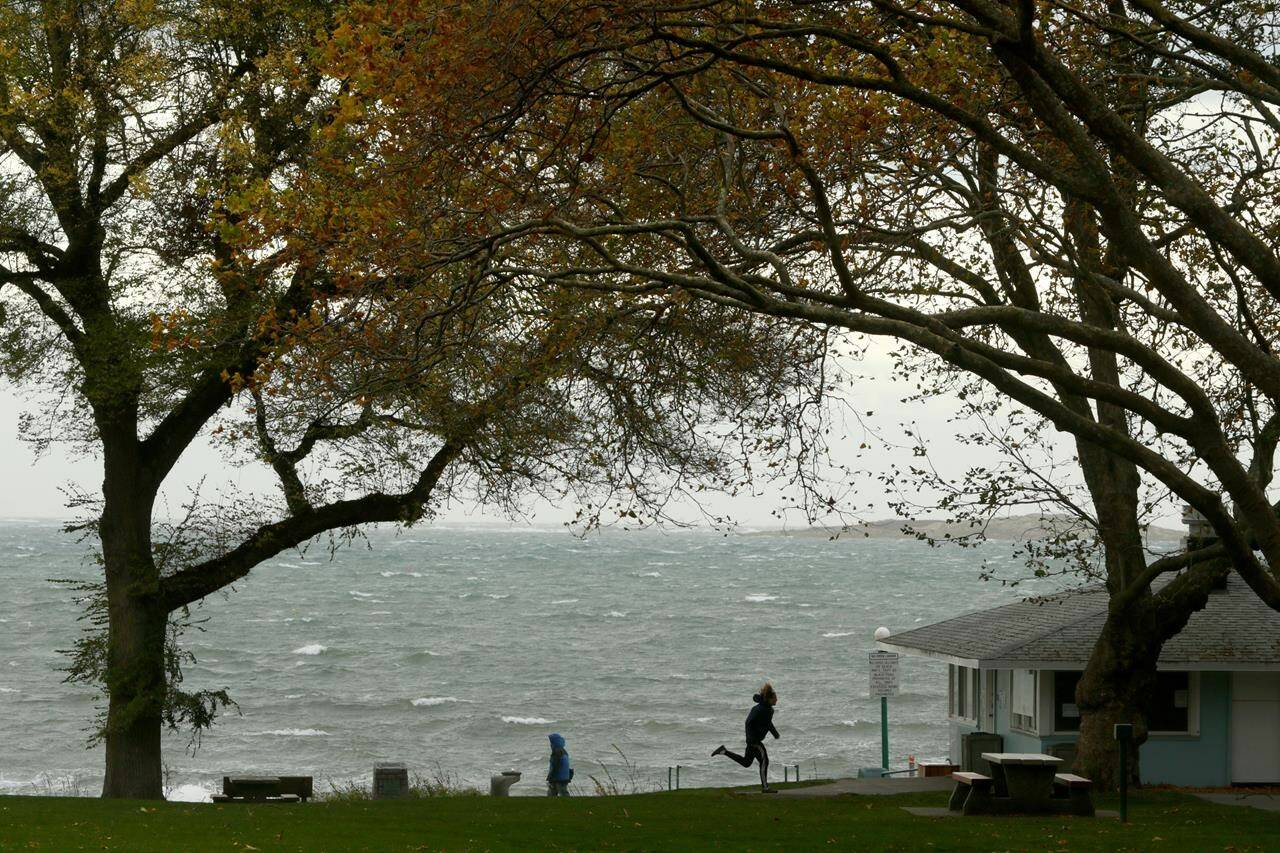 A special weather statement was issued for the Greater Victoria area as southeasterly winds gusting up to 90km per hour were forecasted as people walk along Willow’s beach in Victoria, Monday, Oct. 25, 2021. Environment Canada has issued cold and winter storm warnings for several areas in B.C. THE CANADIAN PRESS/Chad Hipolito