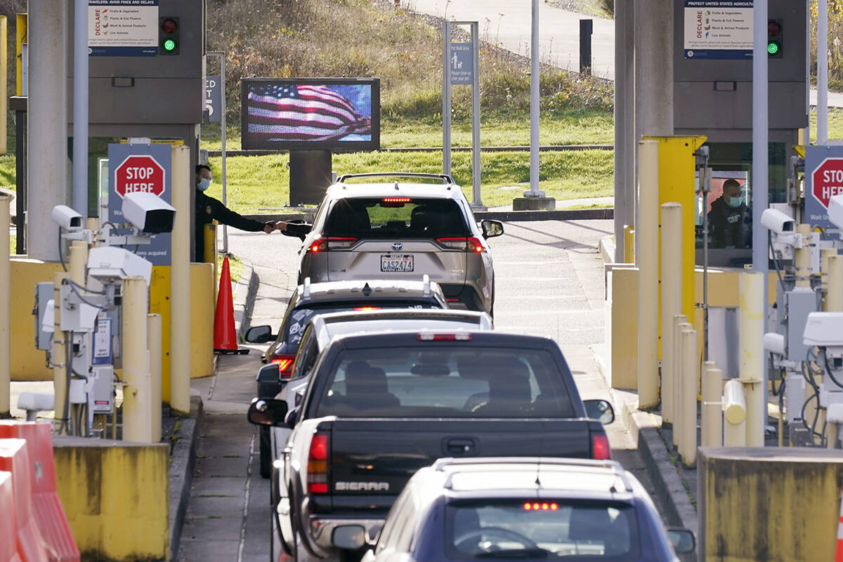 Cars line up to enter the U.S. from Canada at the Peace Arch border crossing Monday, Nov. 8, 2021, in Blaine, Wash. The U.S. reopened its land borders to nonessential travel Monday after almost 20 months of COVID-19 restrictions. Travel across land borders from Canada and Mexico has been largely restricted to workers whose jobs are deemed essential. New rules will allow fully vaccinated foreign nationals to enter the U.S. regardless of the reason. (AP Photo/Elaine Thompson)