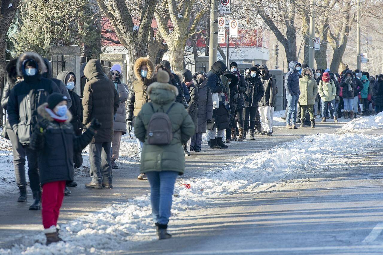 People wait in line to receive a COVID-19 test in Montreal, Tuesday, December 21, 2021, as the COVID-19 pandemic continues in Canada and around the world. THE CANADIAN PRESS/Graham Hughes