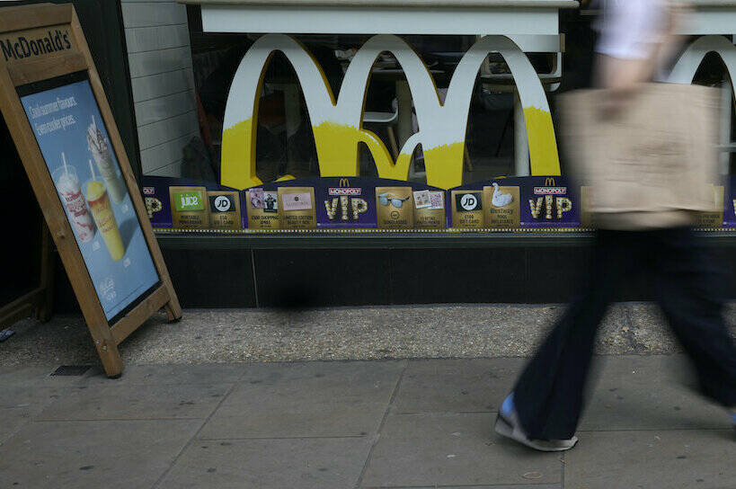 A woman walks by a McDonald’s restaurant, in London, Tuesday, Aug. 24, 2021. McDonald’s says it has pulled milkshakes from the menu in all 1,250 of its British restaurants because of supply problems stemming from a shortage of truck drivers. The fast-food chain says it is also experiencing shortages of bottled drinks. (AP Photo/Alastair Grant)