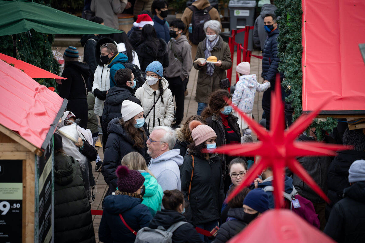 People wear face masks to curb the spread of COVID-19 while visiting the Christmas Market in Vancouver, on Thursday, December 23, 2021. THE CANADIAN PRESS/Darryl Dyck