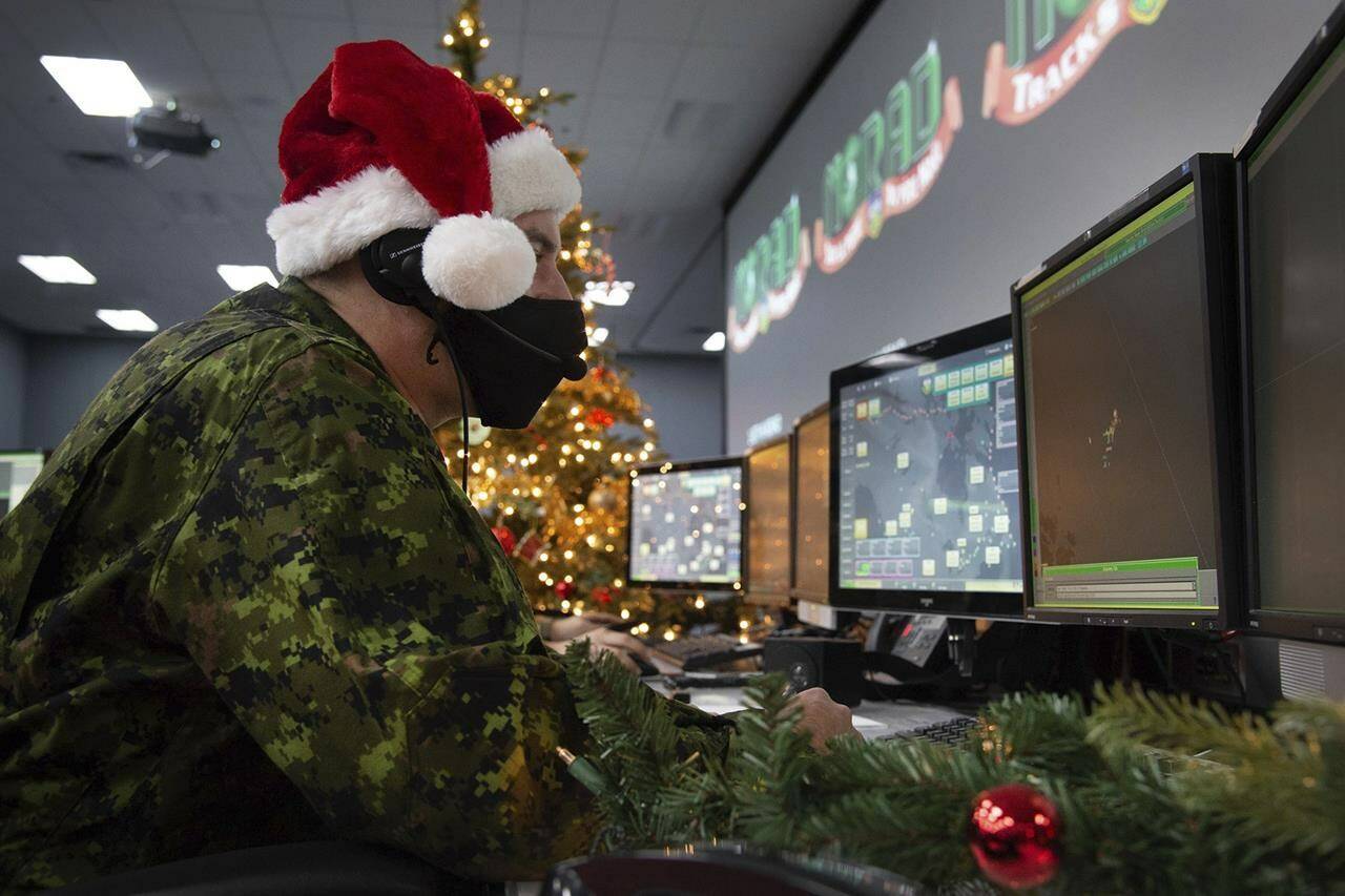 In this photo provided by the North American Aerospace Defense Command, a 22 Wing member is seen showing how they track Santa on his sleigh on Christmas evening during a media preview at the Canadian Forces Base in North Bay on Dec. 9, 2021. In a Christmas Eve tradition going on its 66th year, a wildly popular program run by the U.S. and Canadian militaries is providing real-time updates on Santa’s progress around the globe — and fielding calls from children who want to know St. Nick’s exact whereabouts. (Sable Brown/NORAD via AP)