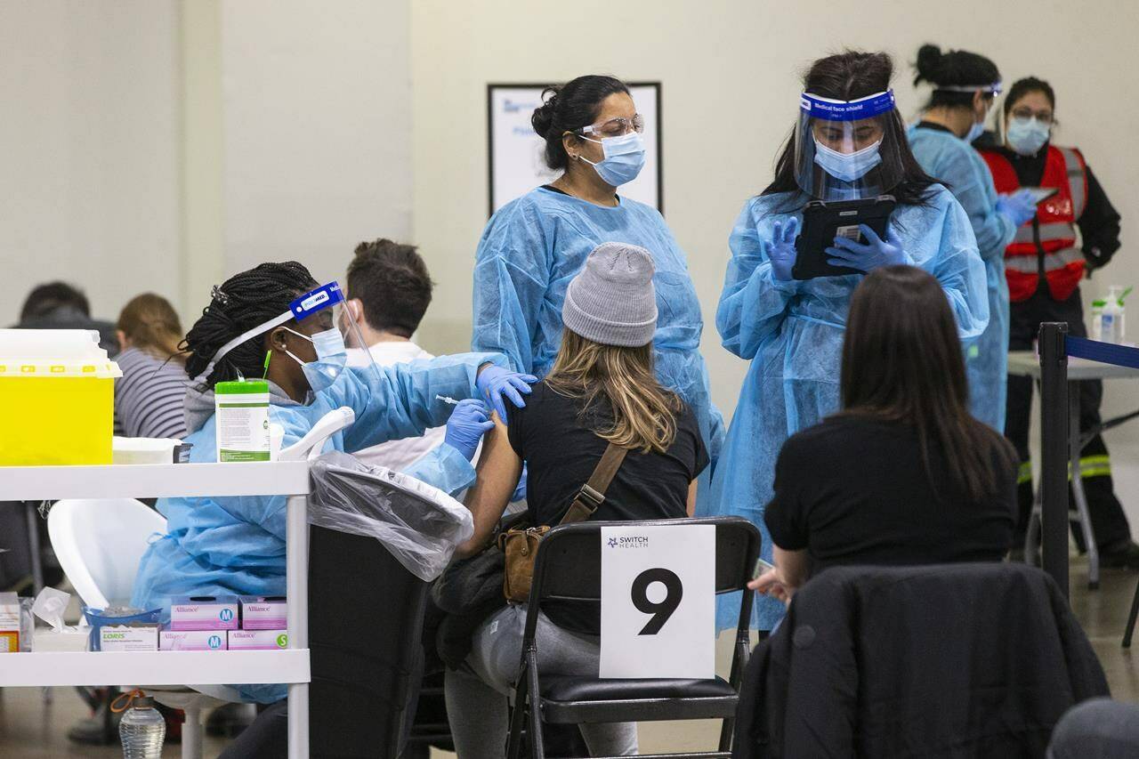 A nurse administers a COVID-19 vaccine at a mass vaccination clinic in Mississauga, Ont., Friday, Dec. 24, 2021. Christmas Day for many Canadians this year means fewer people gathered around a twinkling tree tearing open presents, but others say COVID-19 hasn’t changed their holiday plans. THE CANADIAN PRESS/Chris Young