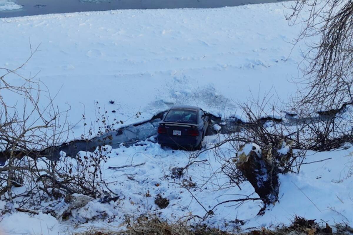 On Dec. 26, 2021, Tracy Smith’s 1995 Mustang hit ice on Schubert Drive in Kamloops, careening between two trees and over the embankment sideways, avoiding a rollover and ending up nose-first in the river, its rear wheels on an iced-over portion of the waterway. (Tracy Smith photo)
