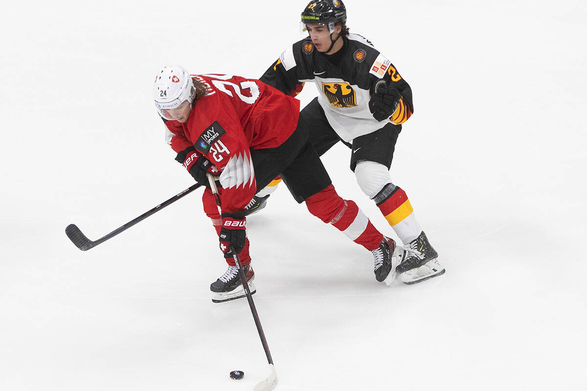 Germany’s Jan Munzenberger (27) chases Switzerland’s Noah Meier (24) during third period IIHF World Junior Hockey Championship action in Edmonton on Wednesday, December 30, 2020. THE CANADIAN PRESS/Jason Franson