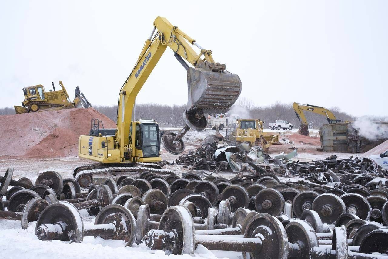 An excavator moves railcar wheels at the site of a CP train derailment near Craven, Sask. on Wednesday, Dec. 29, 2021. THE CANADIAN PRESS/Michael Bell