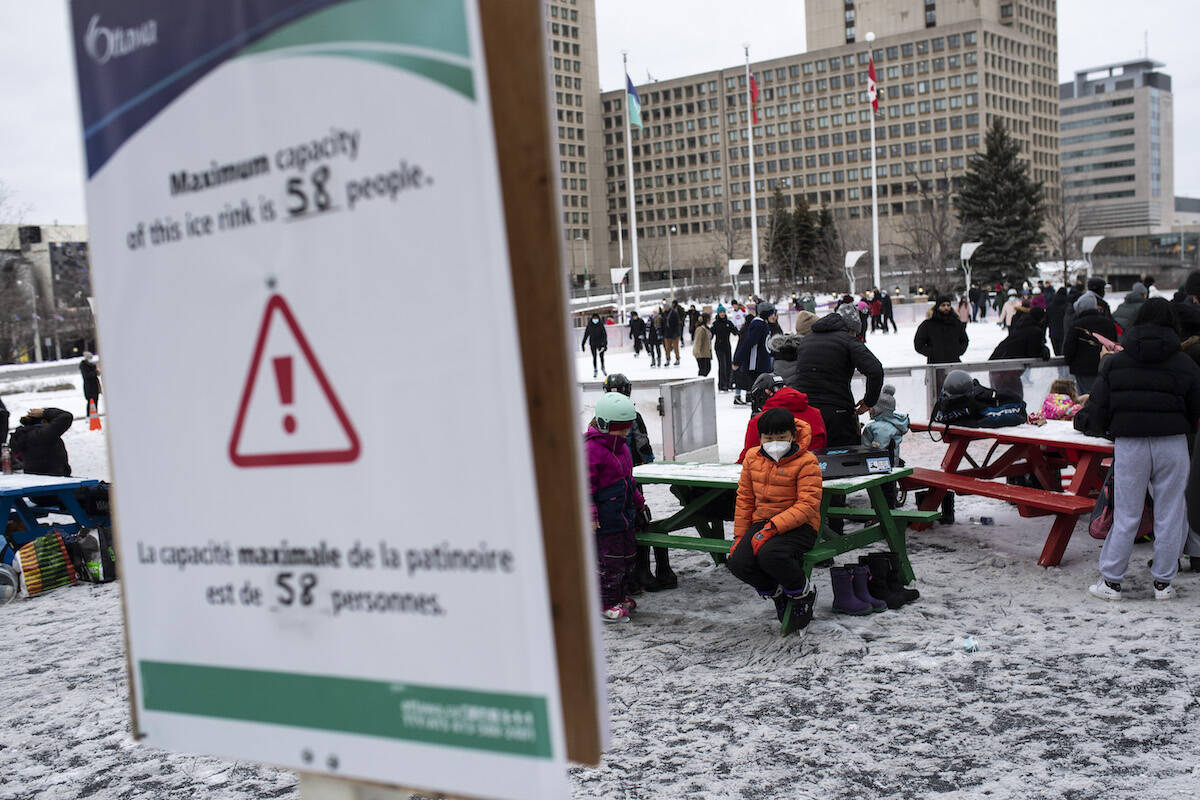 A sign is seen advising a capacity limit for skaters on the ice due to the COVID-19 Omicron variant at the Rink of Dreams at City Hall in Ottawa, on Tuesday, Dec. 28, 2021. THE CANADIAN PRESS/Justin Tang