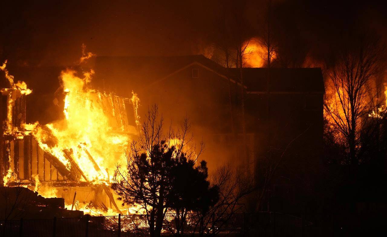 Homes burn as a wildfire rips through a development near Rock Creek Village, Thursday, Dec. 30, 2021, near Broomfield, Colo. An estimated 580 homes, a hotel and a shopping center have burned and tens of thousands of people were evacuated in wind-fueled wildfires outside Denver, officials said Thursday evening. (AP Photo/David Zalubowski)