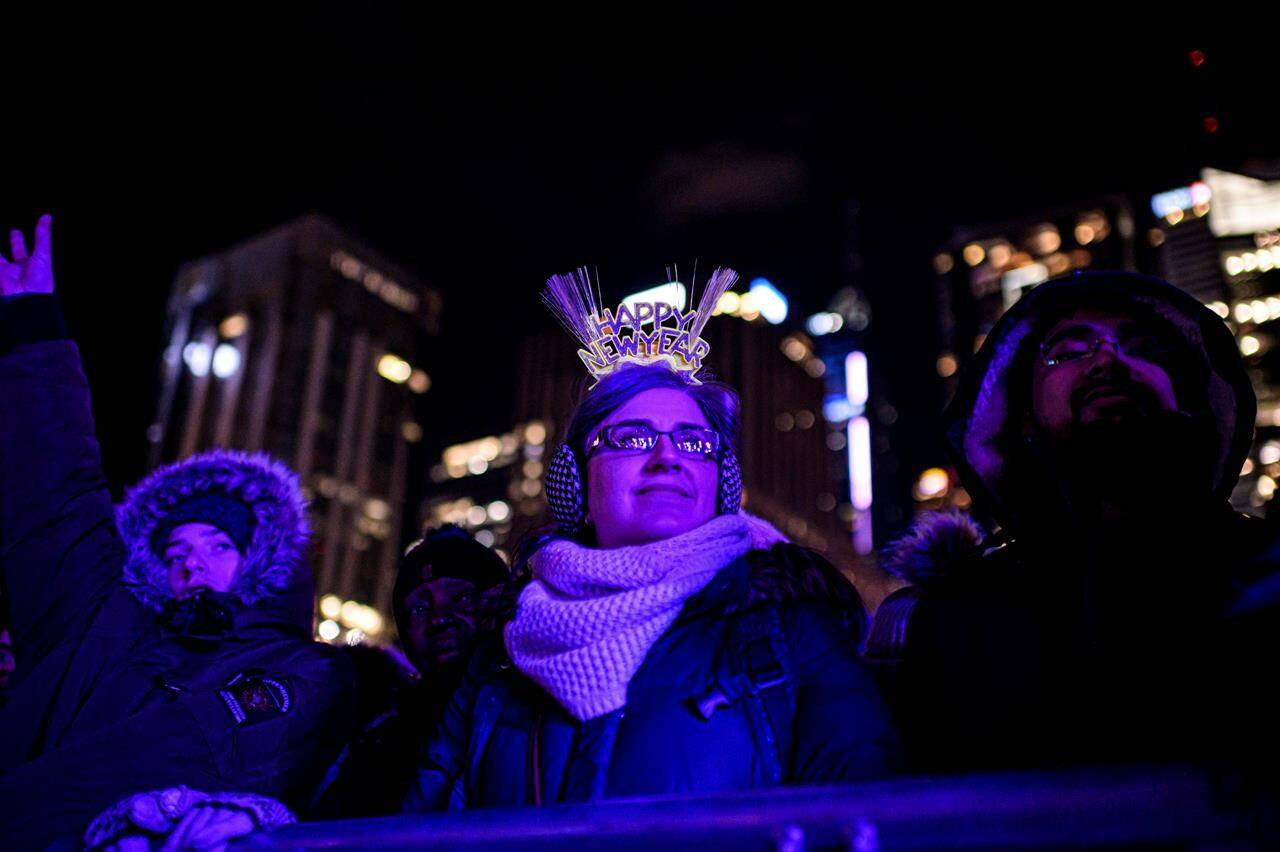 People watch the New Year’s celebrations before midnight at Nathan Philips Square in Toronto, Tuesday, Dec. 31, 2019. Canada’s major cities are set to ring in the New Year with more of a gentle chime than a resounding clang, with many official celebrations cancelled or moved online for the second year in a row due to COVID-19. THE CANADIAN PRESS/Christopher Katsarov