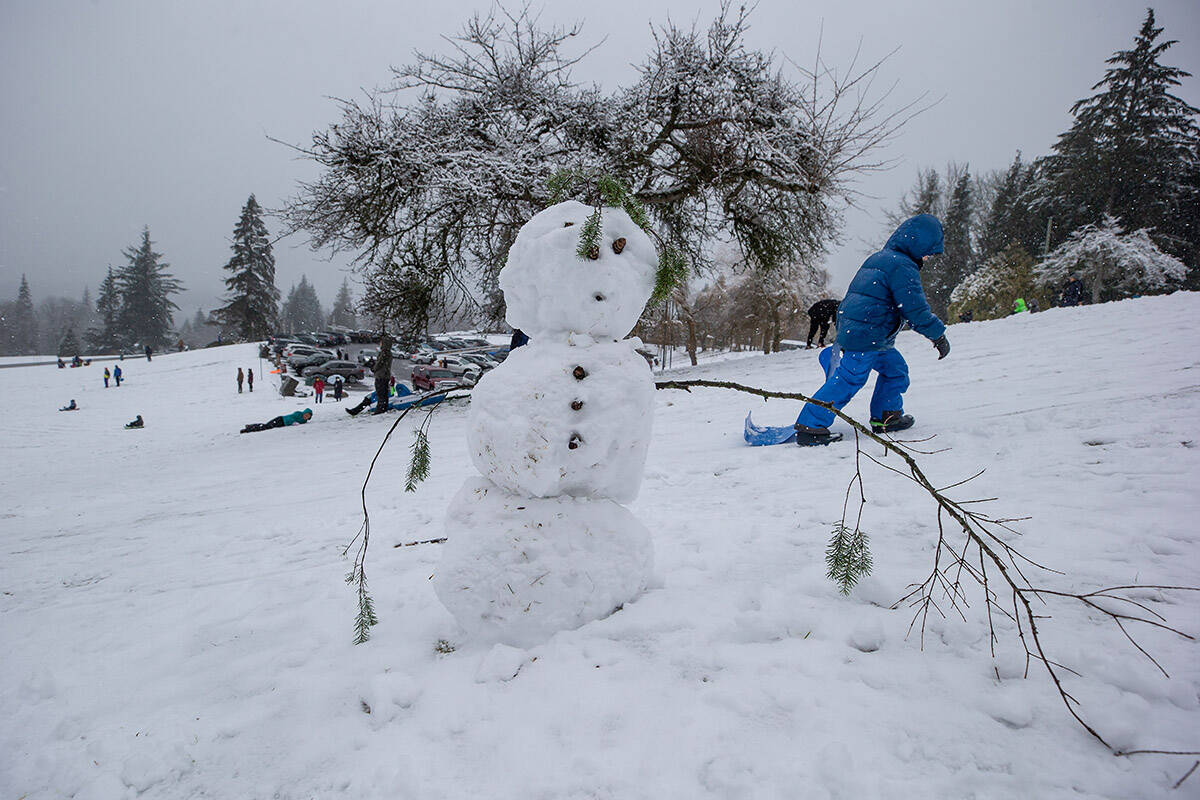 A child walks back up a hill past a snowman while sledding at Burnaby Mountain Park, in Burnaby, B.C., on Sunday, January 24, 2021. Environment Canada issued a snowfall warning for the south coast of British Columbia with 2 to 15 cm expected from Sunday to Monday. THE CANADIAN PRESS/Darryl Dyck