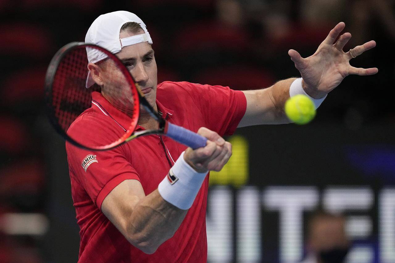 United States’ John Isner hits a forehand to Canada’s Brayden Schnur match at the ATP Cup tennis tournament in Sydney, Sunday, Jan. 2, 2022. (AP Photo/Rick Rycroft)