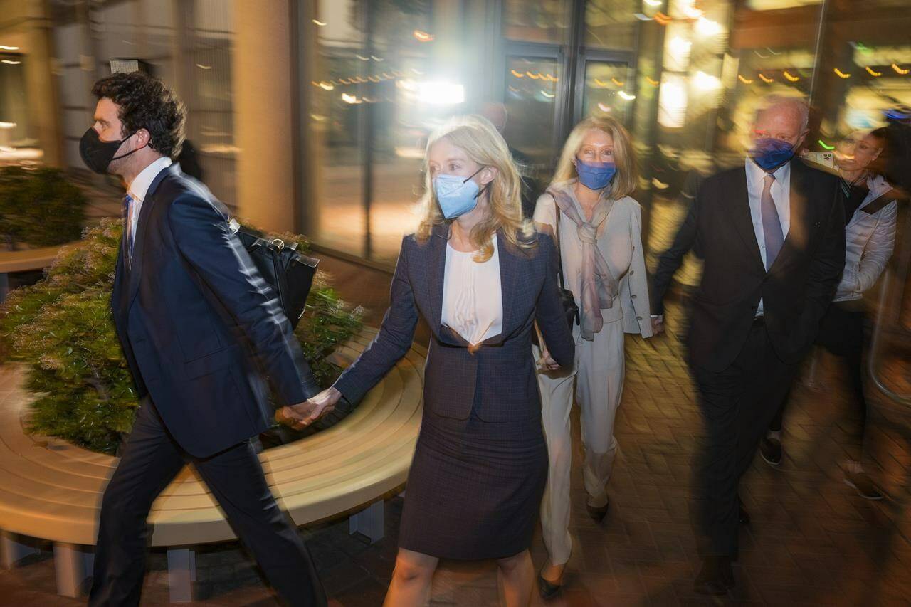 Elizabeth Holmes, second from left, walks out of federal court in San Jose, Calif., Friday, Dec. 17, 2021. (AP Photo/Nic Coury)