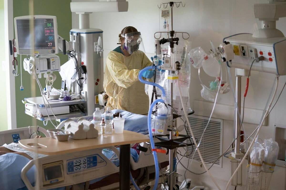 A nurse attends to a patient at the COVID-19 intensive care unit at Surrey Memorial Hospital, June 2021. (The Canadian Press)