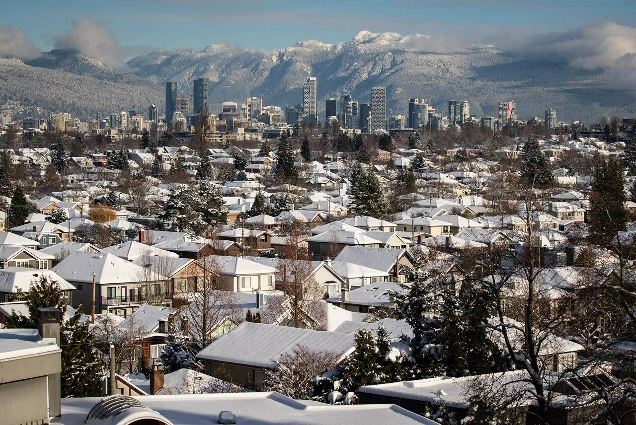 Snow-covered houses and the downtown skyline are seen with the North Shore mountains in the distance in Vancouver on Thursday, December 30, 2021. Those who own a home in British Columbia valued at just under $2 million will still be eligible for the annual homeowner grant. THE CANADIAN PRESS/Darryl Dyck