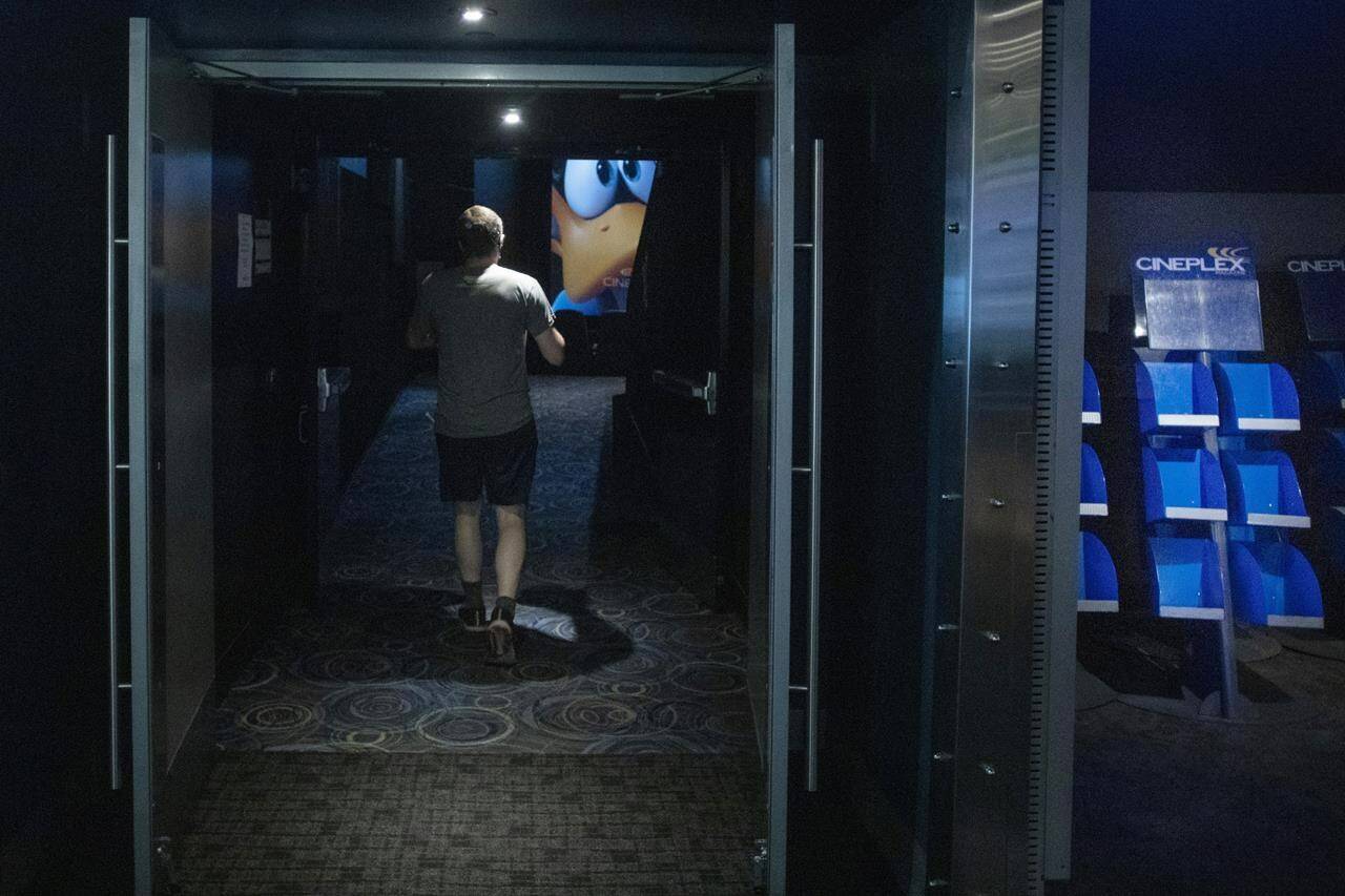 A moviegoer steps into an auditorium at a Cineplex Movie Theatre in Toronto on Friday, July 16, 2021. Cineplex Inc. says it has temporarily laid off nearly 5,000 part-time employees because of mandated closures of its Ontario movie theatres.THE CANADIAN PRESS/Chris Young