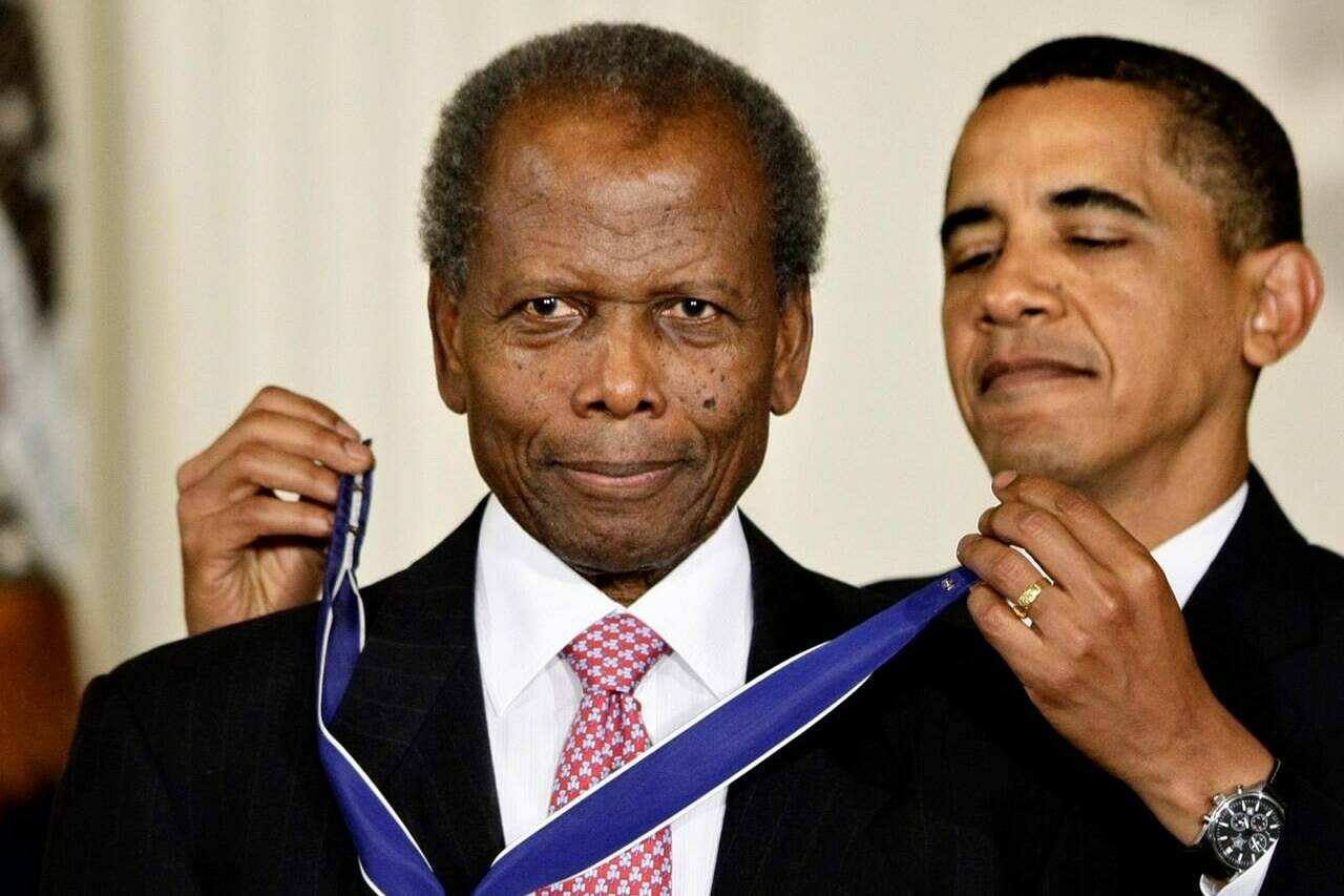 FILE - President Barack Obama presents the 2009 Presidential Medal of Freedom to Sidney Poitier during ceremonies in the East Room at the White House in Washington on, Aug. 12, 2009. Poitier, the groundbreaking actor and enduring inspiration who transformed how Black people were portrayed on screen, became the first Black actor to win an Academy Award for best lead performance and the first to be a top box-office draw, died Thursday, Jan. 6, 2022 in the Bahamas. He was 94. (AP Photo/J. Scott Applewhite, File)