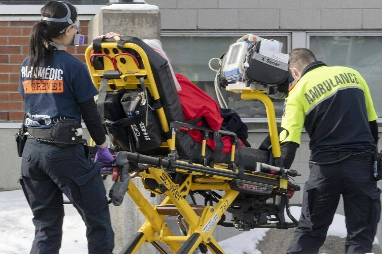 Ambulance workers transport a patient to the emergency room as hospitalizations continue to rise due to the COVID-19 pandemic, in Montreal, Wednesday, Jan. 5, 2022. Canada's chief public health officer Dr. Theresa Tam says the Omicron variant is causing an "enormous" volume of COVID-19 cases, but severe illness is not rising at the same rate. THE CANADIAN PRESS/Ryan Remiorz