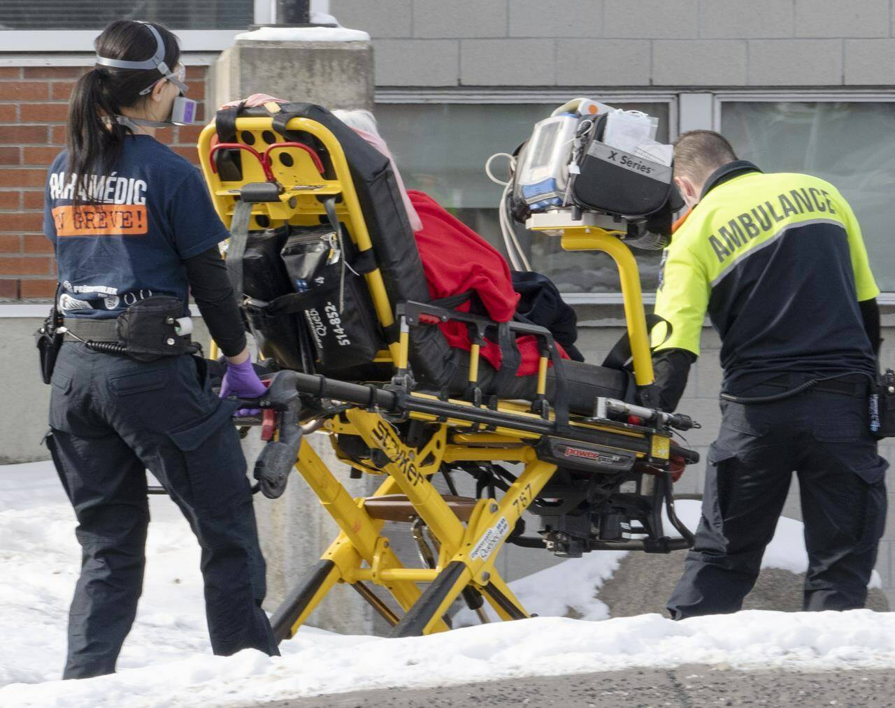 Ambulance workers transport a patient to the emergency room as hospitalizations continue to rise due to the COVID-19 pandemic Wednesday, January 5, 2022 in Montreal. THE CANADIAN PRESS/Ryan Remiorz