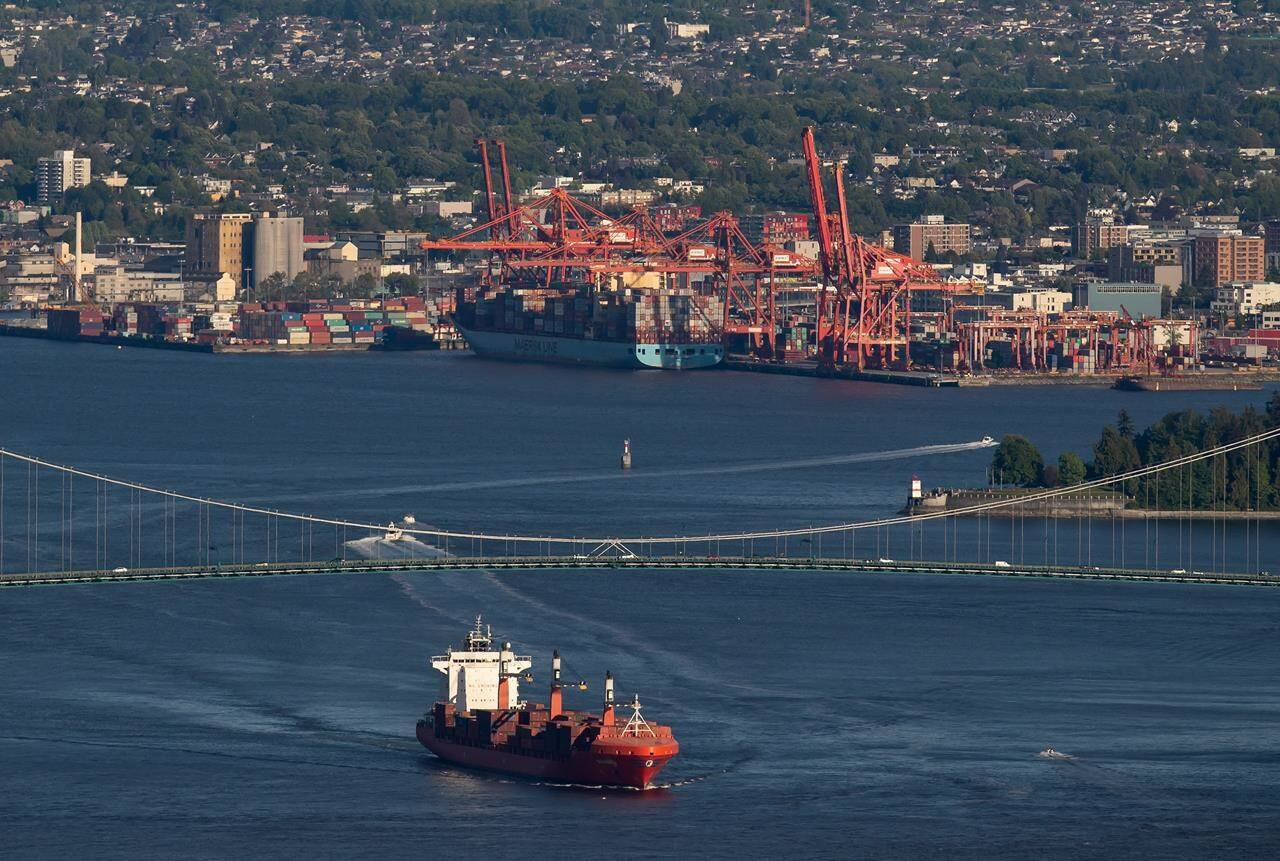 The container ship Ballenita passes under the Lions Gate Bridge after leaving port, in Vancouver, B.C., Monday, May 18, 2020. Canada’s largest private sector union is calling on the federal government to push back a port plan that would impose tighter environmental restrictions on container trucks. THE CANADIAN PRESS/Darryl Dyck