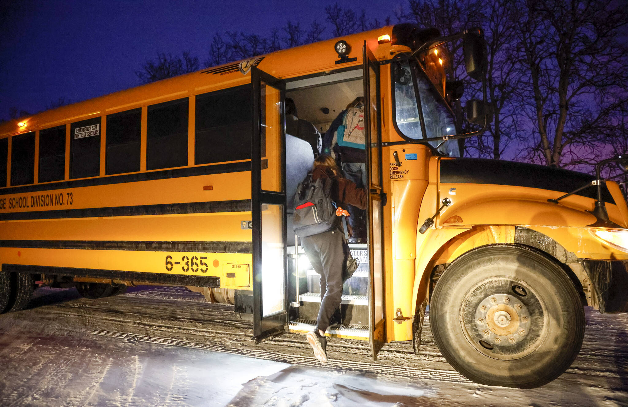 Alberta students board a school bus as they return to school today for the first time since their holiday break was extended due to surging COVID-19 cases, near Cremona, Alta., Monday, Jan. 10, 2022. THE CANADIAN PRESS/Jeff McIntosh