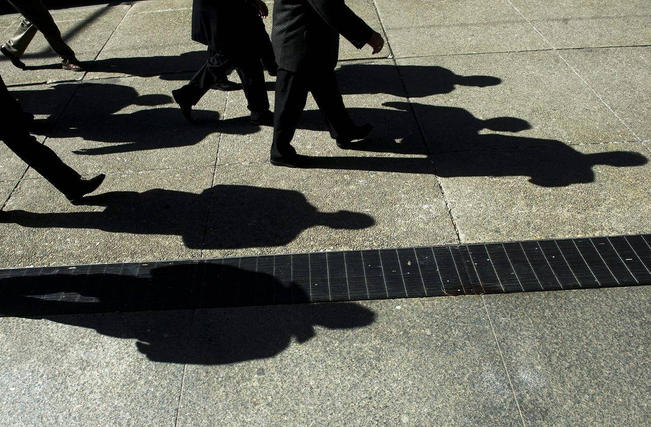 Business people cast their shadows as they walk in Toronto’s financial district on Monday, Feb. 27, 2012. A majority of respondents in a new Canada-wide survey said equal representation in government is important, but they don’t support employers taking demographic characteristics into account in hiring and promotion decisions. THE CANADIAN PRESS/Nathan Denette