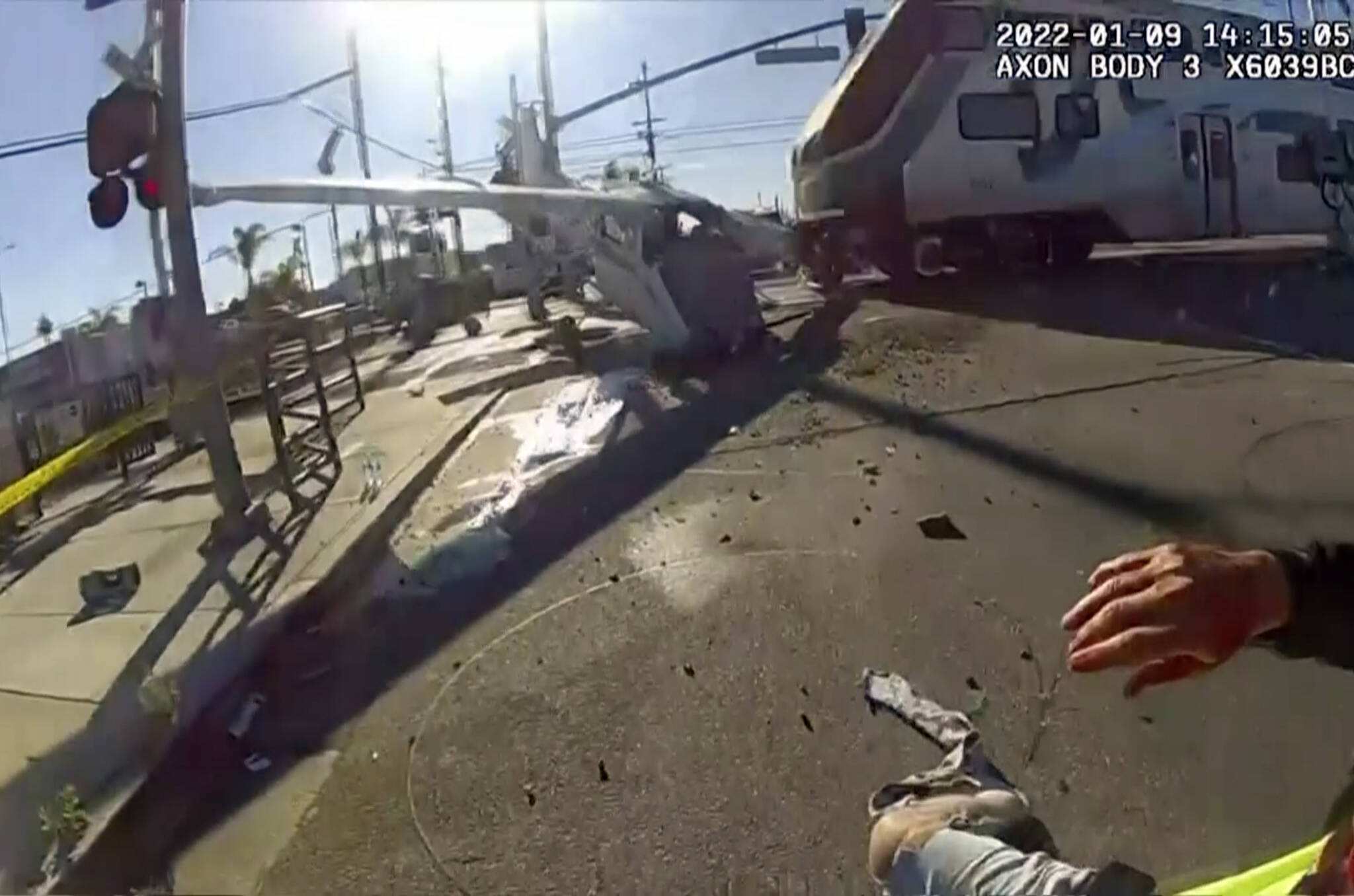 In this screen grab from a body cam video provided by the Los Angeles Police Department, a commuter train crashes with a plane which had just taken off from nearby Whiteman Airport Sunday, Jan. 9, 2021 in Pacoima, Calif. Los Angeles police officers pulled an injured pilot from the wreckage of a small plane that crash landed on railroad tracks just moments before a commuter train smashed into the aircraft over the weekend. (AP Photo/Los Angeles Police Department via AP)