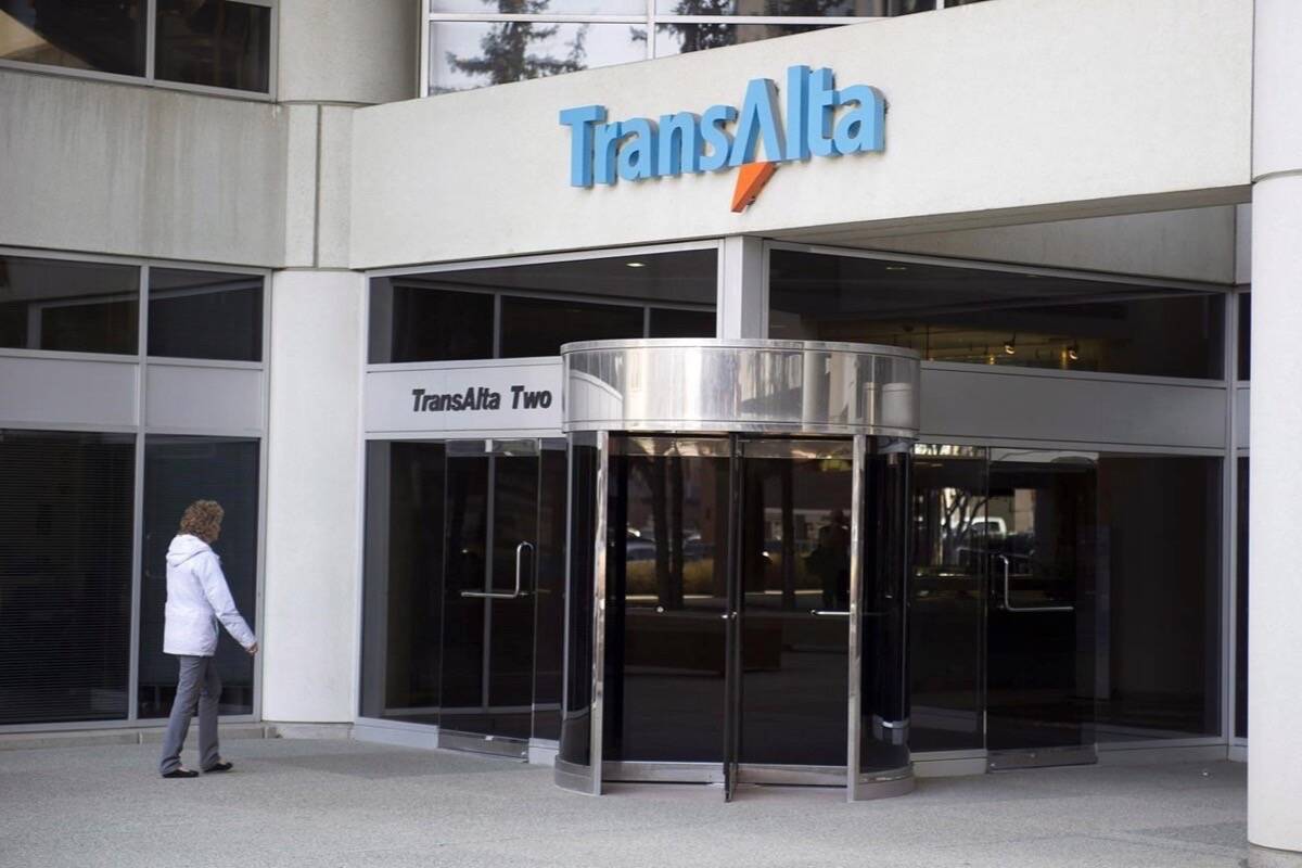 FILE - A woman walks towards the entrance of the TransAlta headquarters building in Calgary on April 29, 2014. THE CANADIAN PRESS/Larry MacDougal