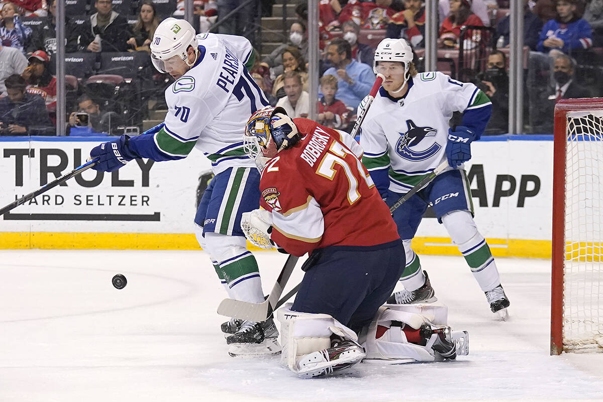 Florida Panthers goaltender Sergei Bobrovsky (72) defends the goal against Vancouver Canucks left wing Tanner Pearson (70) during the first period of an NHL hockey game, Tuesday, Jan. 11, 2022, in Sunrise, Fla. (AP Photo/Lynne Sladky)