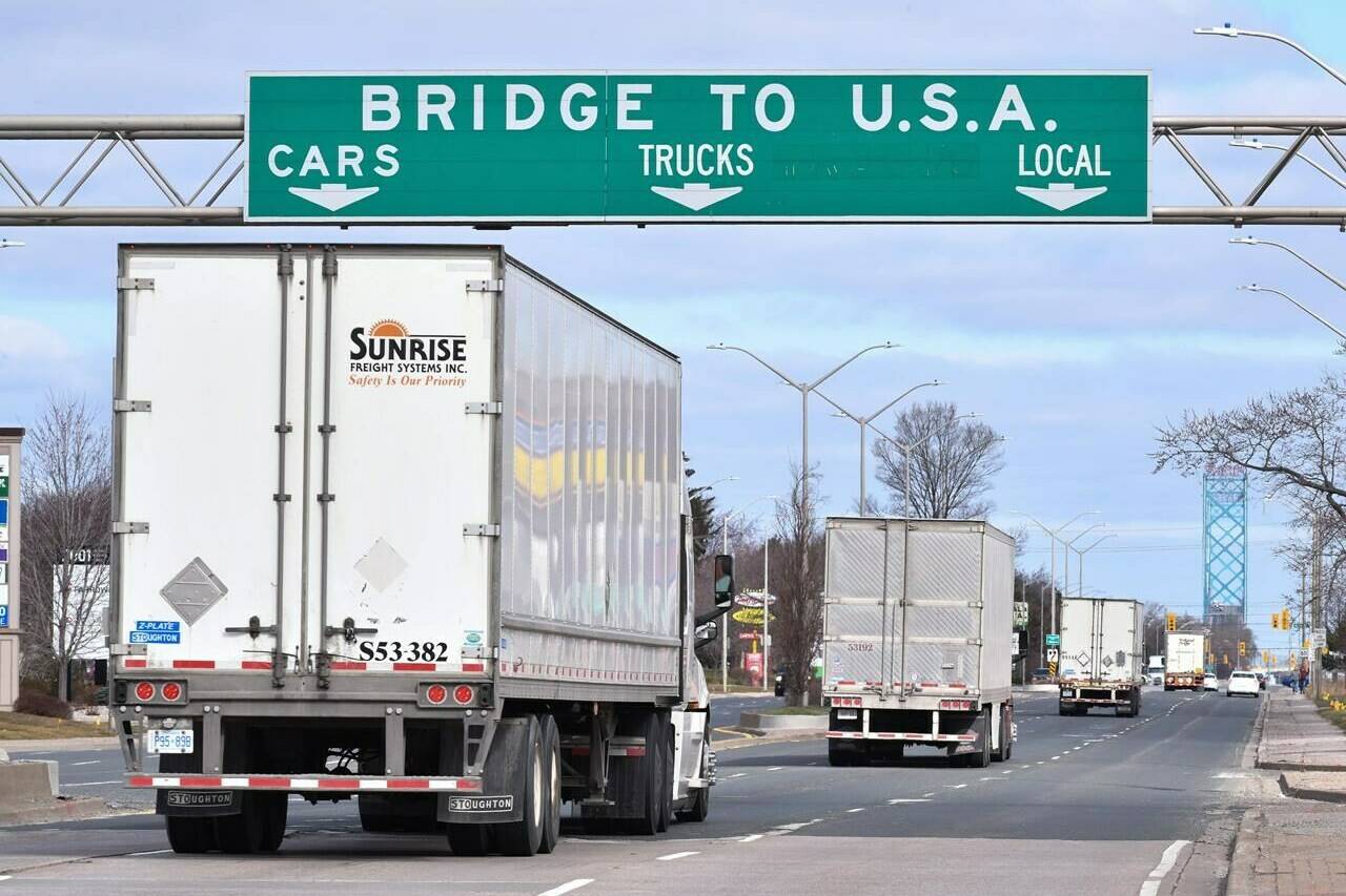 Transport trucks approach the Canada/USA border crossing in Windsor, Ont. on Saturday, March 21, 2020. Only days before Canadian truck drivers were required to be fully vaccinated to get into the country or face quarantine, the federal government is backing away from the vaccine mandate. THE CANADIAN PRESS/Rob Gurdebeke
