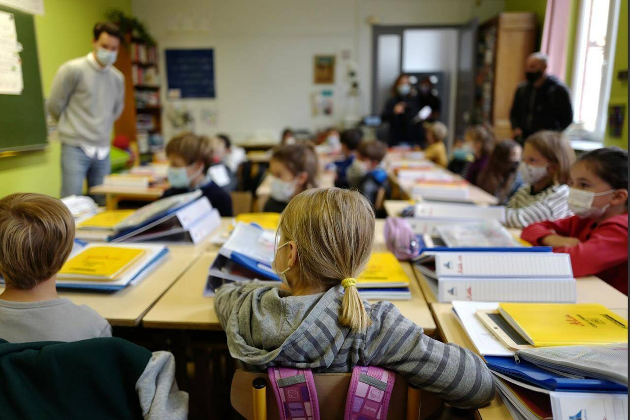FILE-Students attend class on the first day of school for the 2021-2022 year at Gounod Lavoisier Primary school in Lille, northern France, Thursday, Sept. 2 2021. Less than two weeks after the winter term started, French teachers are already exhausted by the pressures of surging COVID-19 cases and they are walking out in nationwide strike organized by their unions to protest virus-linked class disruptions and ever-changing isolation rules. (AP Photo/Michel Spingler, File)