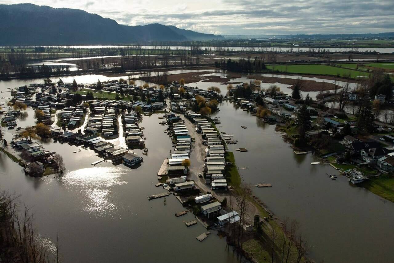 Properties on Hatzic Lake are surrounded by high water after floodwaters began to recede, near Mission, B.C., Sunday, Dec. 5, 2021. A new report on the need for Canada to become better prepared for climate disasters says a lack of critical data is preventing governments and individuals from making better decisions about adapting to and preventing the effects of climate change. THE CANADIAN PRESS/Darryl Dyck