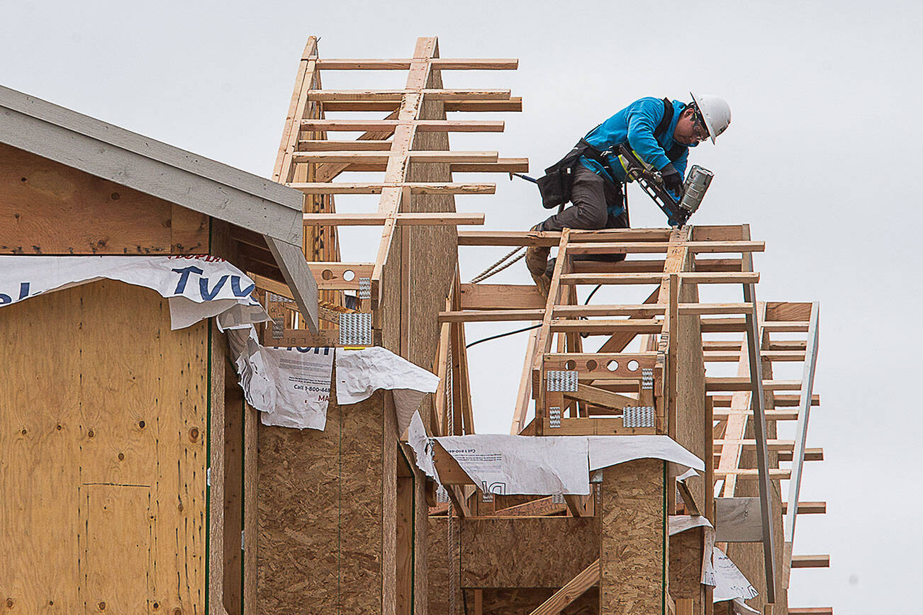 A construction worker works on the roof line of apartments under construction in the 1600 block of E. Marine View Drive on Friday, April 24, 2020 in Everett, Wa. (Andy Bronson / The Herald)