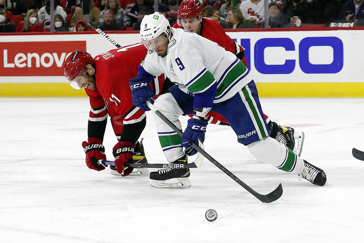Vancouver Canucks’ J.T. Miller (9) wins a battle for the puck against Carolina Hurricanes’ Jordan Staal (11) during the second period of an NHL hockey game in Raleigh, N.C., Saturday, Jan. 15, 2022. (AP Photo/Karl B DeBlaker)