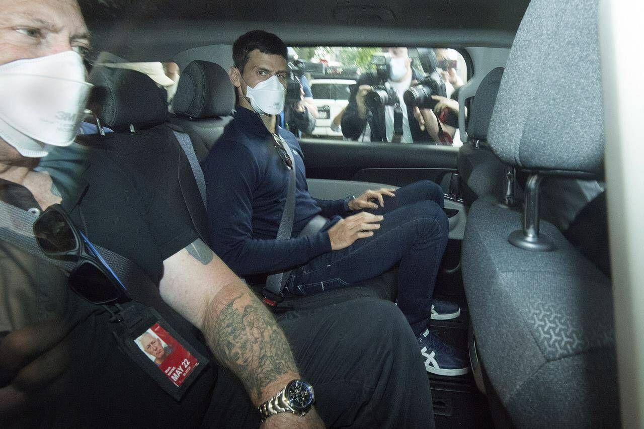 Serbian tennis player Novak Djokovic, center, rides in car as he leaves a government detention facility before attending a court hearing at his lawyers office in Melbourne, Australia, Sunday, Jan. 16, 2022. A federal court hearing has been scheduled for Sunday, a day before the men’s No. 1-ranked tennis player and nine-time Australian Open champion was due to begin his title defense at the first Grand Slam tennis tournament of the year. (James Ross/AAP via AP)